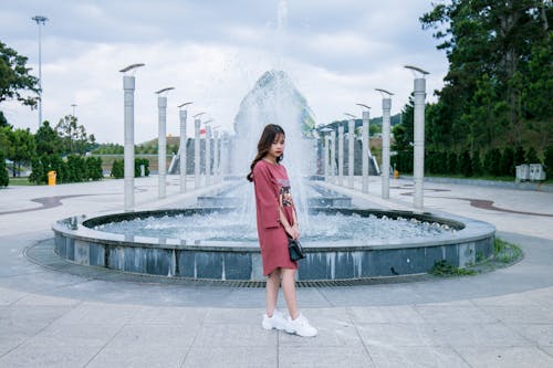 Woman Wearing Pink Crew-neck Long-sleeved Midi Dress Standing Concrete Outdoor Fountain
