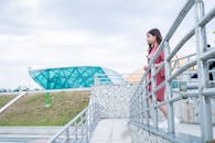 白天，一位妇女走在有玻璃立面的现代建筑旁