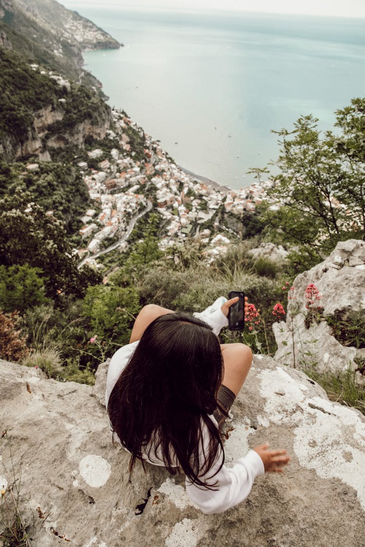 Woman Sitting On The Edge Of A Cliff 