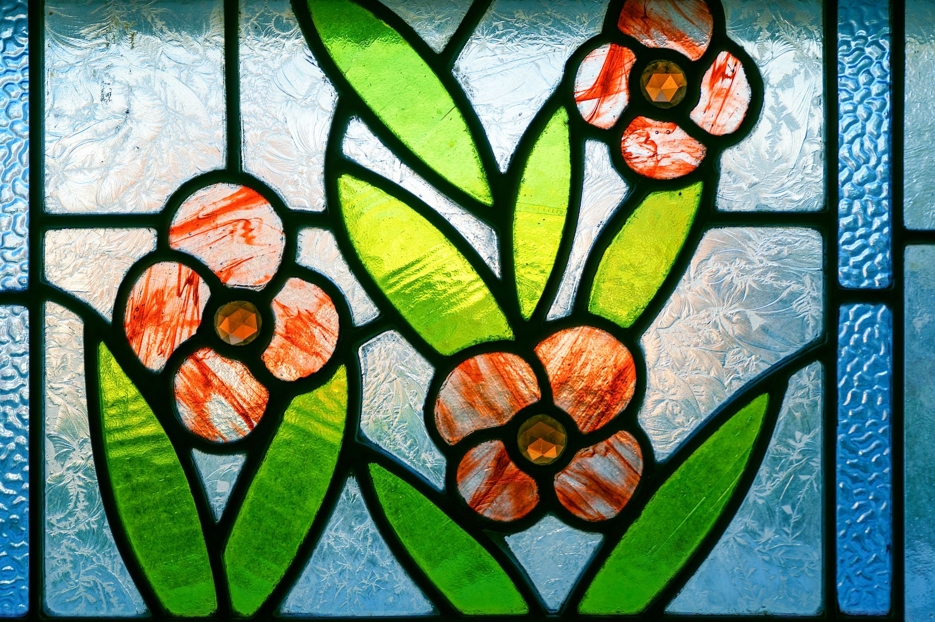 Detailed view of a vibrant stained glass artwork featuring floral patterns.