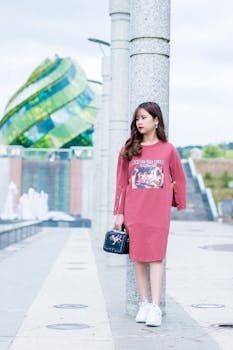 Young woman poses stylishly against modern architecture in a cityscape.