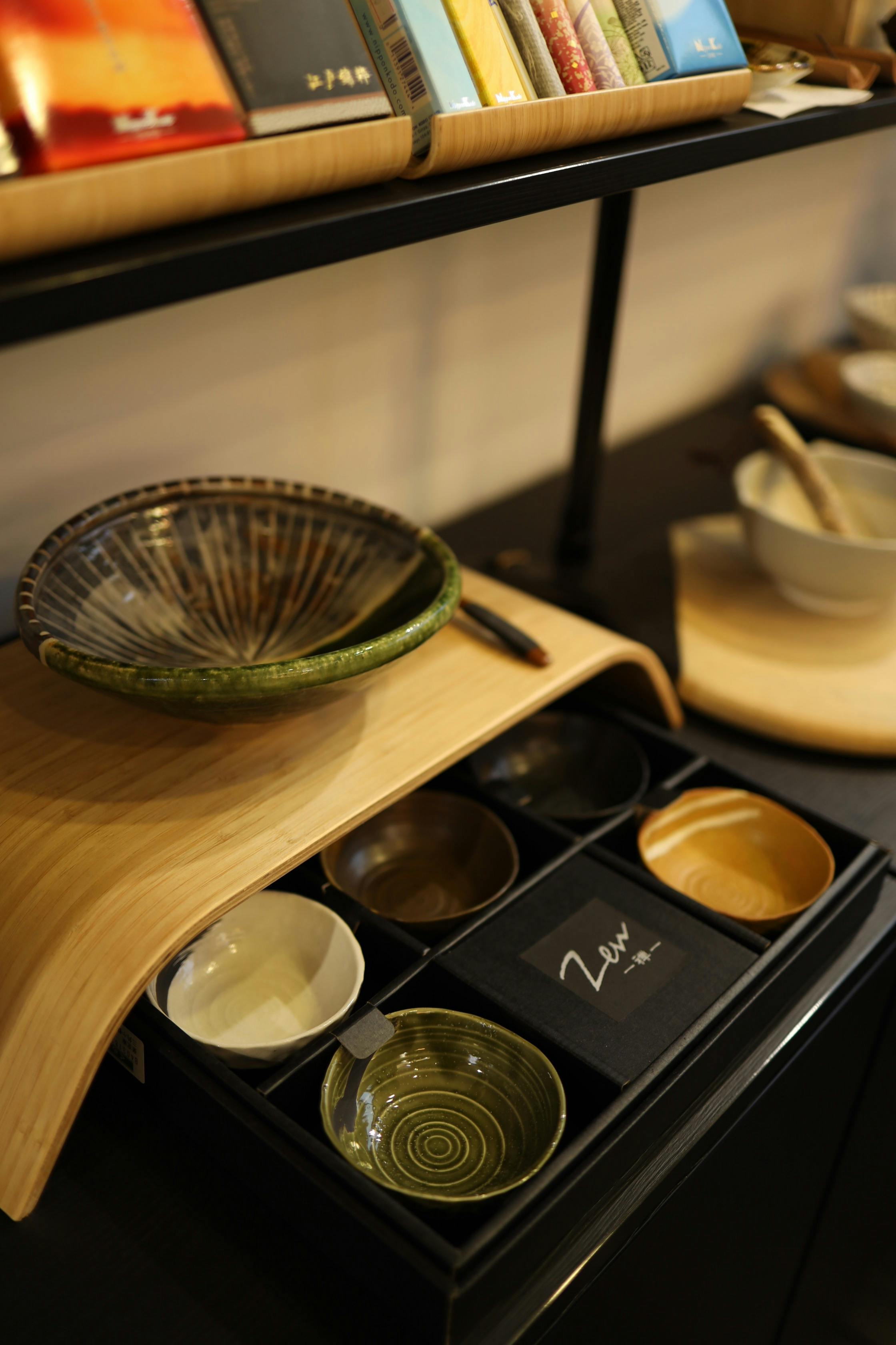 A stylish arrangement of ceramic bowls showcasing modern kitchenware design on a wooden shelf.