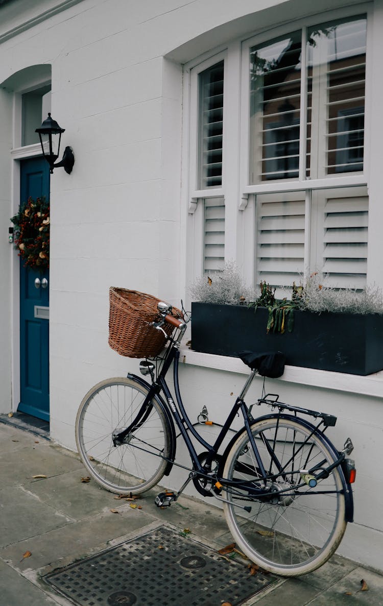 Bicycle Standing By Window With Planter On Windowsill