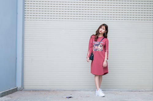 Standing Woman Wearing Red Dress Beside Roll Top Door