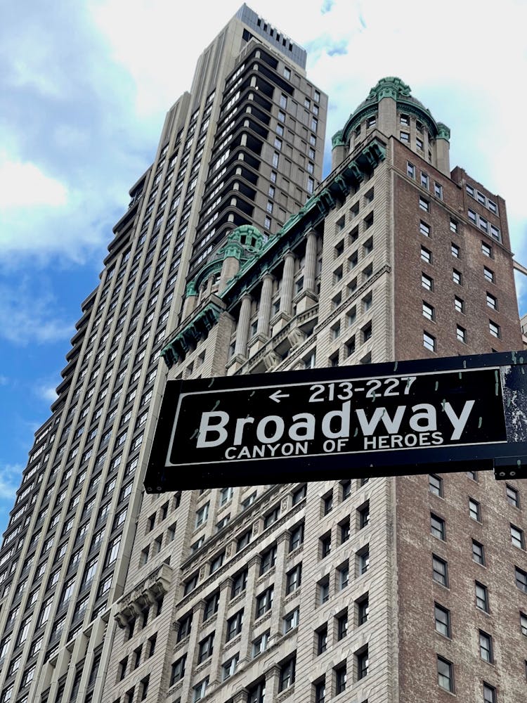 Broadway Street Sign And A Skyscraper 