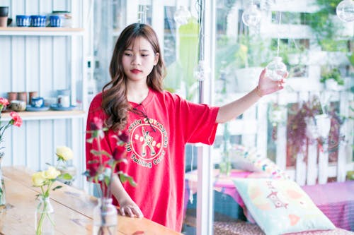 Woman Wearing Red Shirt Holding Hanging Decor