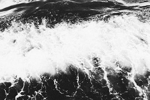 Grayscale Photo of  Crashing Ocean Waves with Seafoam
