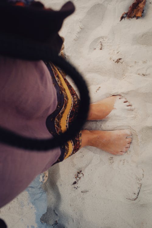 A Person Standing Barefoot in the Sand