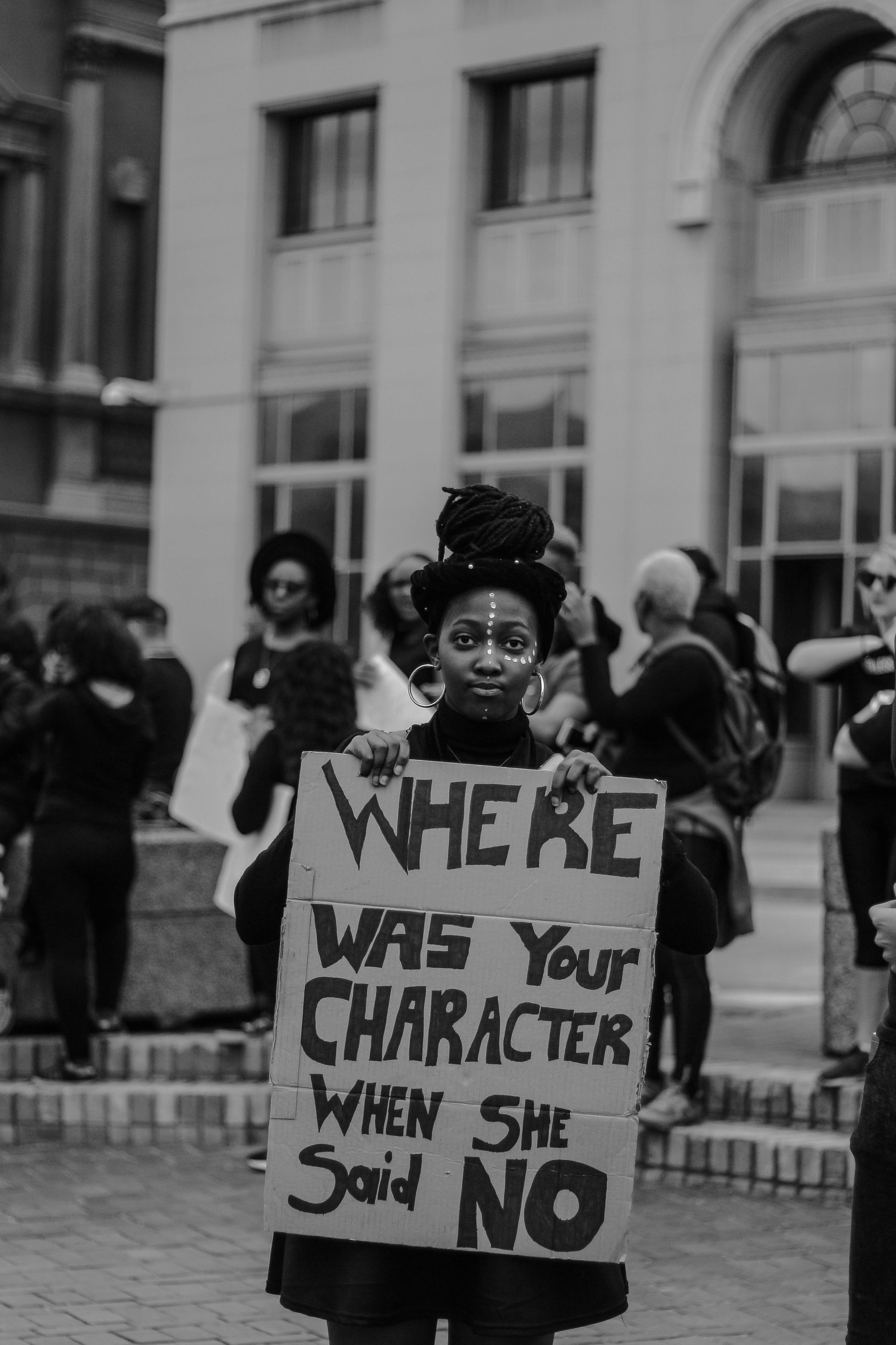 woman holding a placard and protesting against sexual violence