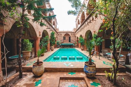 Patio d'un riad marocain avec piscine, zelliges et orangers