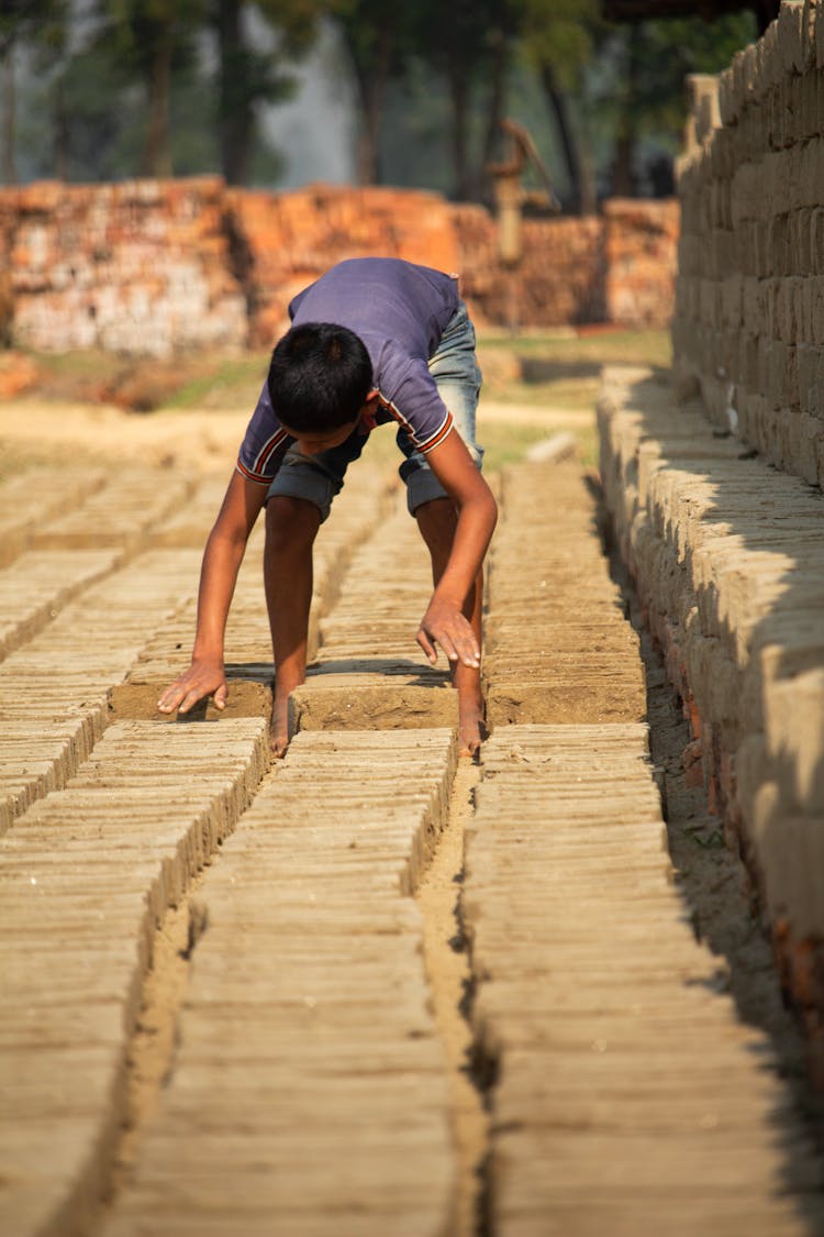 Boy Working At Manufacturing Of Bricks