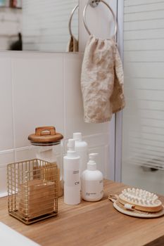 Elegant bathroom with skincare essentials on a wooden surface offering simplicity and style.