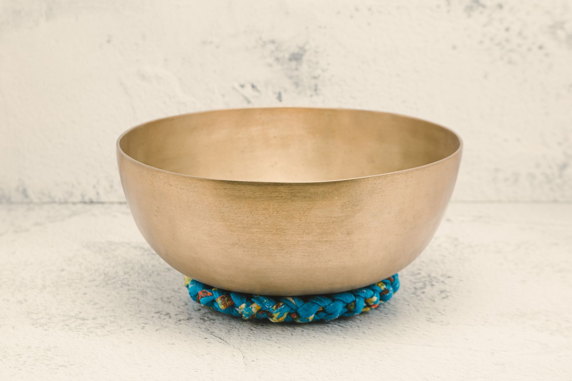 Close-up of a Tibetan singing bowl resting on a vibrant cushion, ideal for meditation practice.