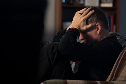 Man Sitting with Hands on Head