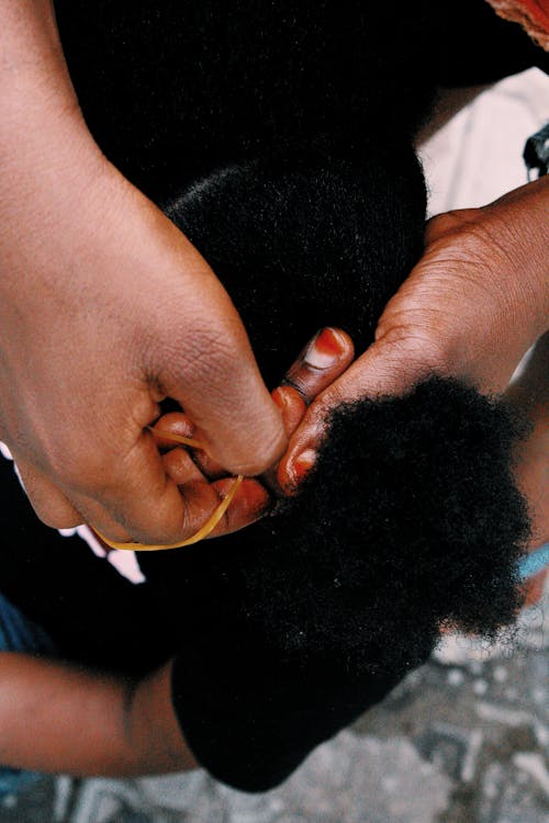 Close-up of Woman Tying Hair of a Girl 