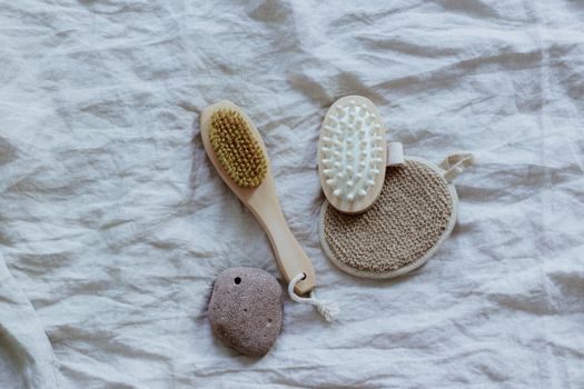 Flat lay of natural spa tools on a textured fabric surface for a minimalist and calming aesthetic.