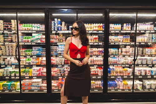 Free Woman in Red and Black Dress Standing in Front of Display Cabinet Stock Photo