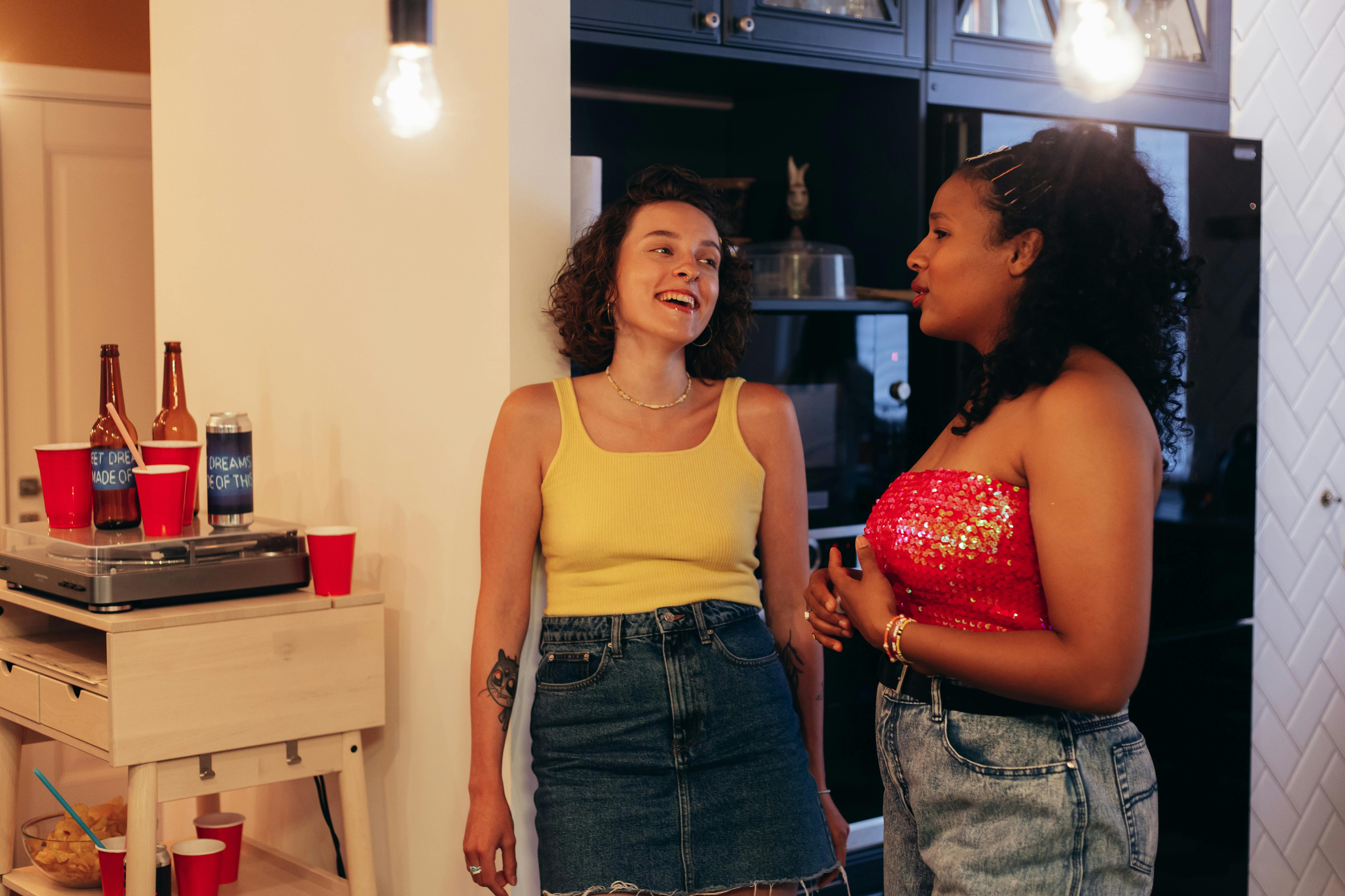 Woman in Yellow Tank Top Talking to Woman in Red Tube · Free Stock Photo