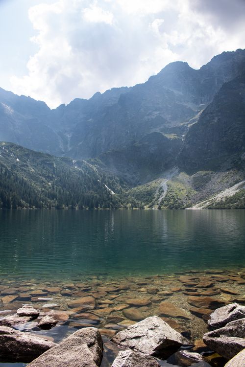 Free Peaceful lake view with the majestic Tatra Mountains in the background under a serene sky. Stock Photo