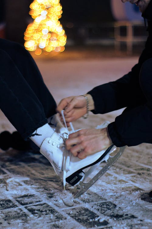 Free A Person in Black Jacket Tying the Skate Lace Stock Photo