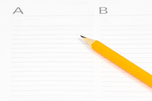 Free Yellow Pencil on White Ruled Paper Stock Photo