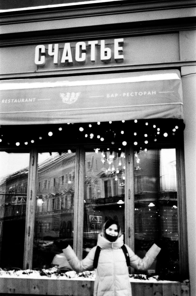 A Woman Standing In Front Of A Restaurant