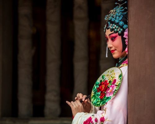 Free Elegant Chinese opera performer in traditional attire with floral fan, showcasing cultural artistry. Stock Photo