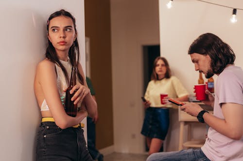 Woman in Silver Crop Top Standing Beside Man in Purple Crew Neck T Shirt