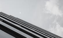 西班牙圣地亚哥德孔波斯特拉，一座现代摩天大楼的低角度视图，天空中可见半月形