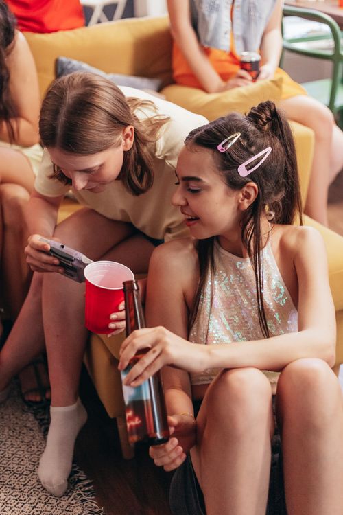 Free A group of young adults enjoying drinks and conversation at a lively home gathering. Stock Photo