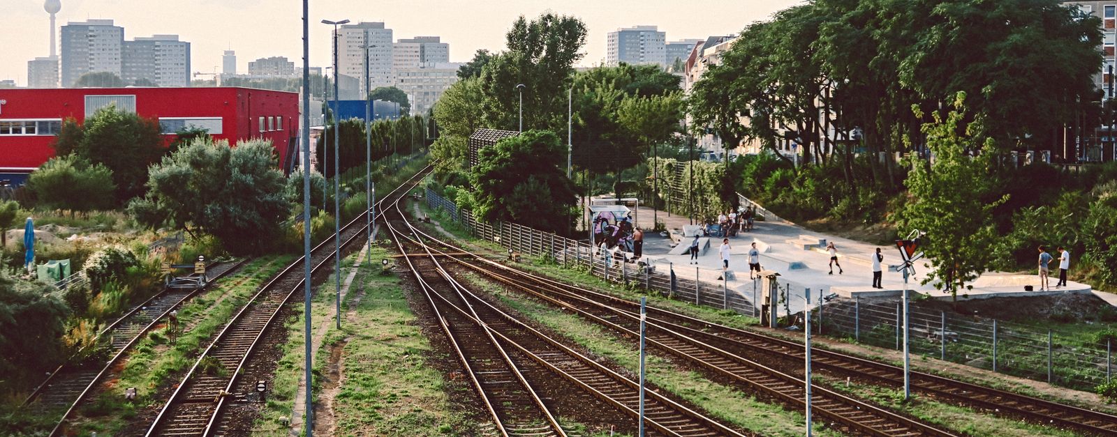 Railway tracks in Berlin with a view of the TV Tower and a nearby skatepark.
