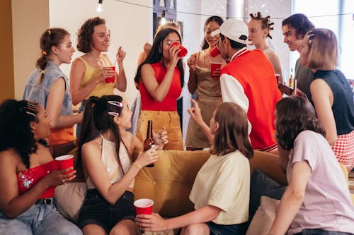 Group of Young People at a Party Drinking from Red Plastic Cups 