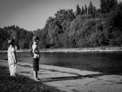 两个孩子沐浴着明媚的阳光，在河边无忧无虑地嬉戏