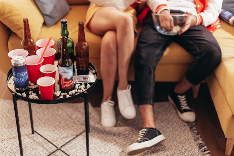 Couple Sitting With Bottles On Table