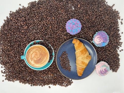 Coffee and Croissant on Beans in Overhead View