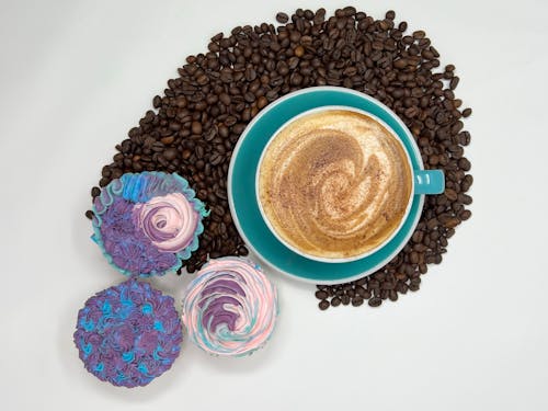 
A Close-Up Shot of a Cup of Cappuccino and Cupcakes