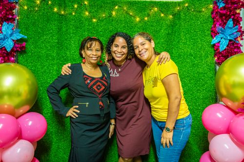 Free Three women smiling and posing with balloons and festive background. Stock Photo