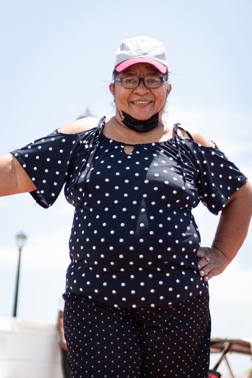 Free Cheerful woman wearing polka dot outfit and cap, posing outdoors on a sunny day. Stock Photo