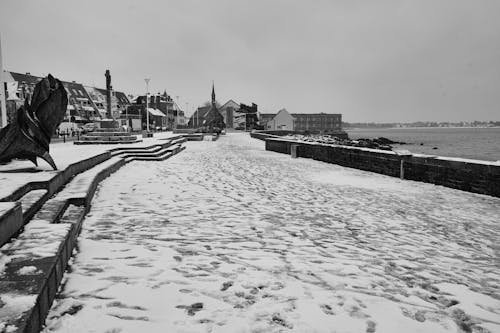Grayscale Photo of a City by the Seaside in Winter