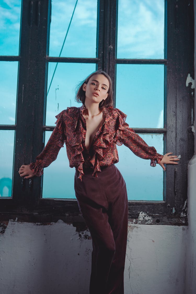 Woman Posing By Large Window With Blue Sky Outside