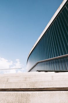 一座蓝色立面的现代化建筑，在晴朗天空下以低角度呈现，展现出时尚的建筑风格