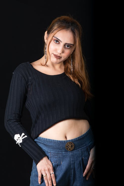 A Woman in Black Long Sleeve Crop Top and Blue Denim Bottoms