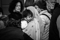 一幅黑白肖像描绘了拥挤市场上一位母亲抱着孩子的场景