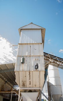 户外工厂里，高大的金属塔、晴朗的天空和工业元素构成了它的景象