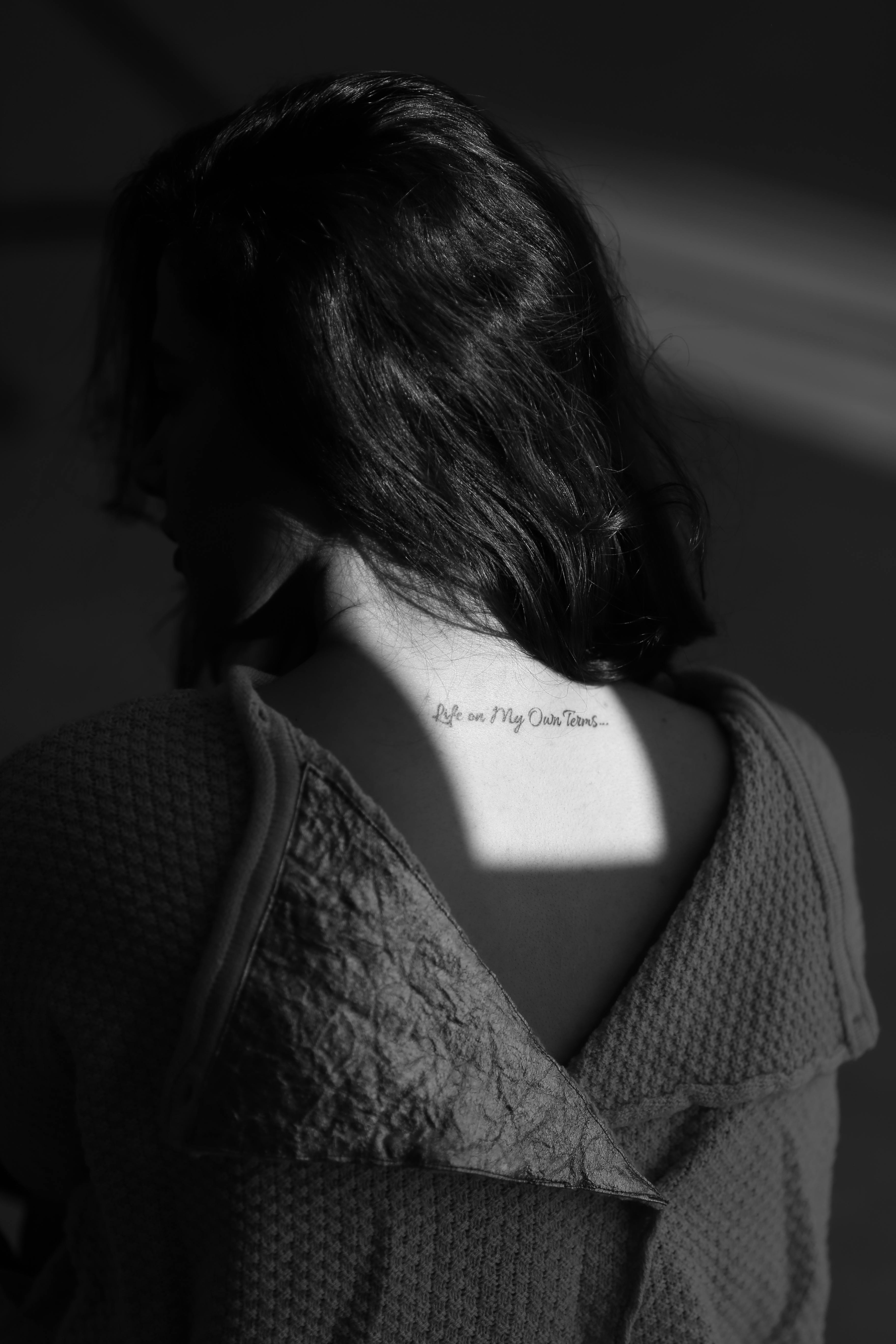black and white photo of woman with tattoo on her back