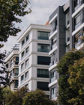 Contemporary apartment structures surrounded by lush trees during the day.