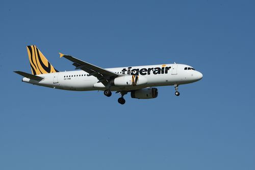 Free Tigerair Airbus A320 in flight against clear blue sky. Stock Photo