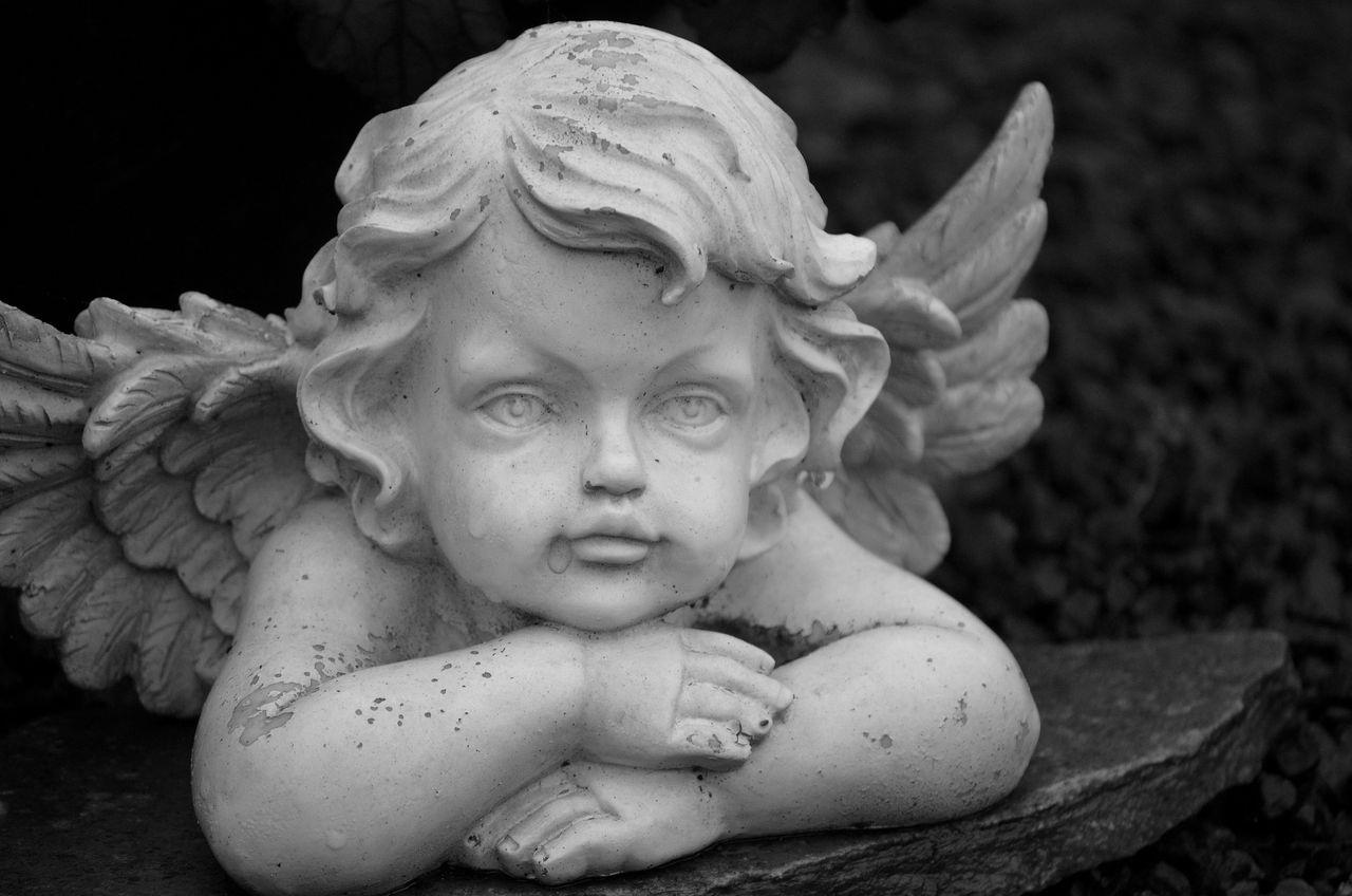 a detailed black and white close up of an angel sculpture in bocholt g