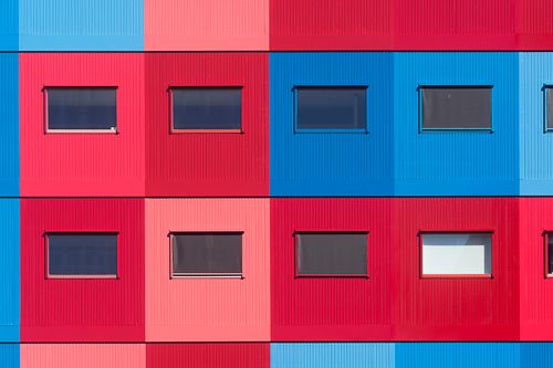 Free Vibrant red and blue building facade showcasing modern architectural design. Stock Photo