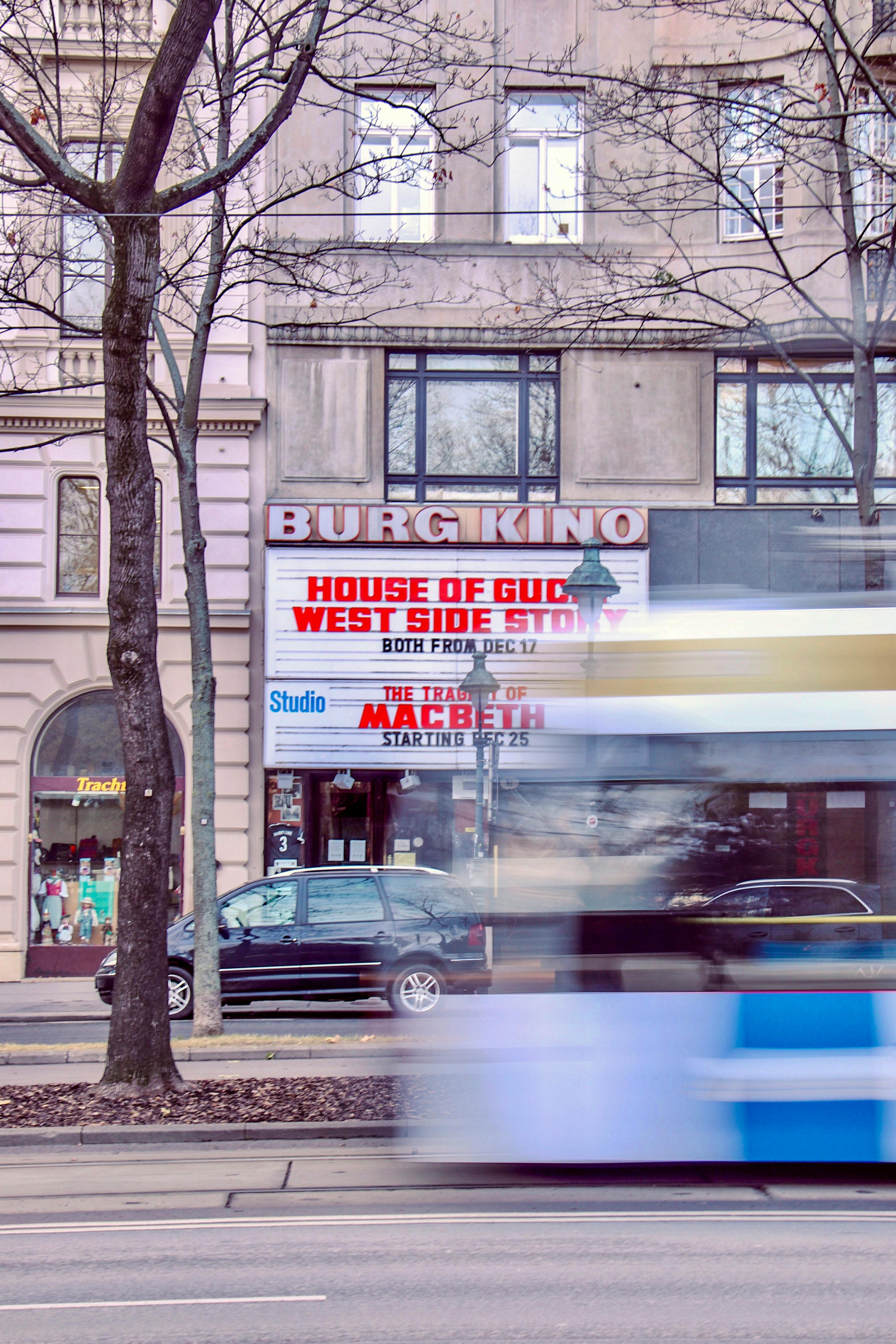 Street view of Burg Kino in Vienna with tram motion blur, capturing the city's cinema culture.